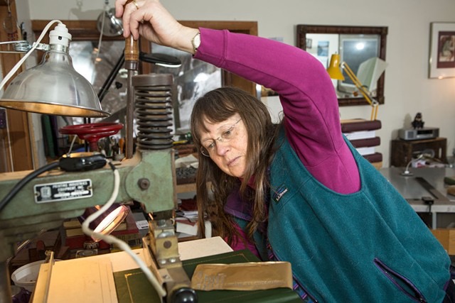 Marianna at the gold stamper, putting a title on a book cover    ~    photo by Oliver Parini